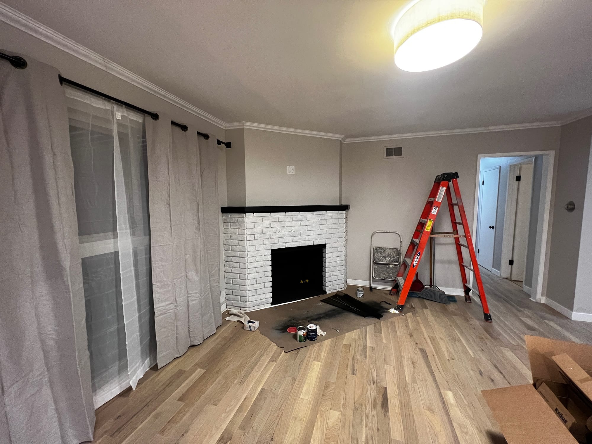 Living room with painted-brick fireplace and new flooring