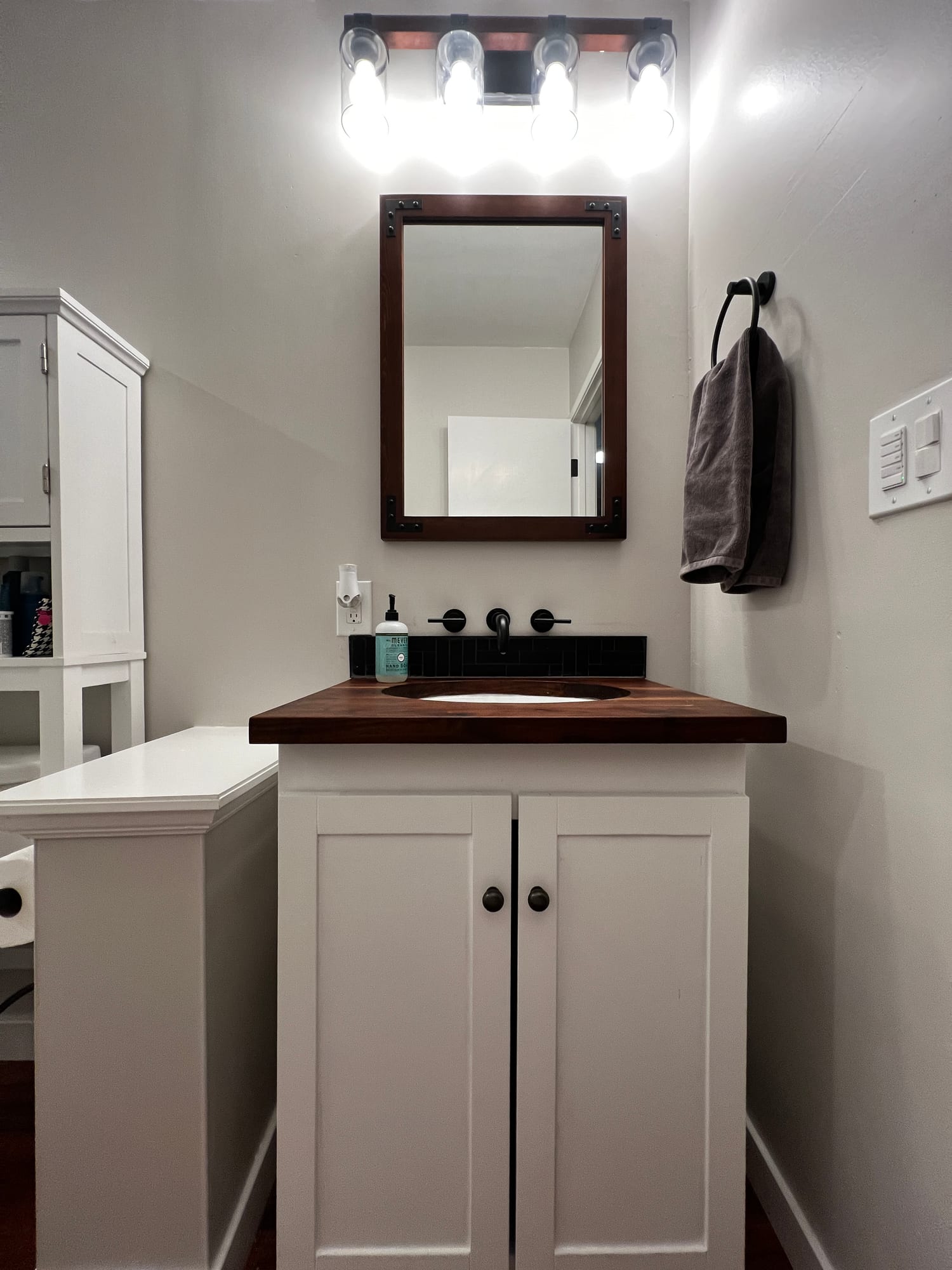Custom walnut-top vanity with black fixtures
