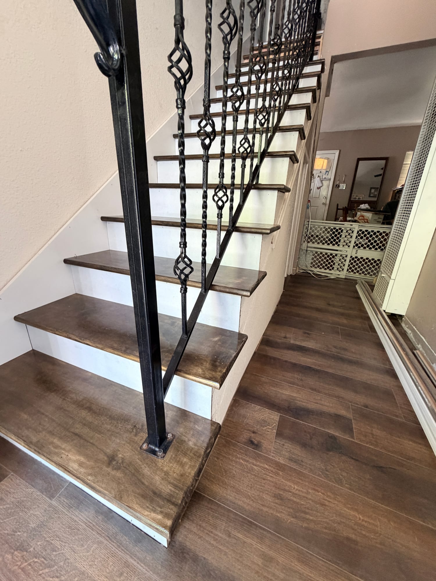 Custom stair treads with wrought-iron railing